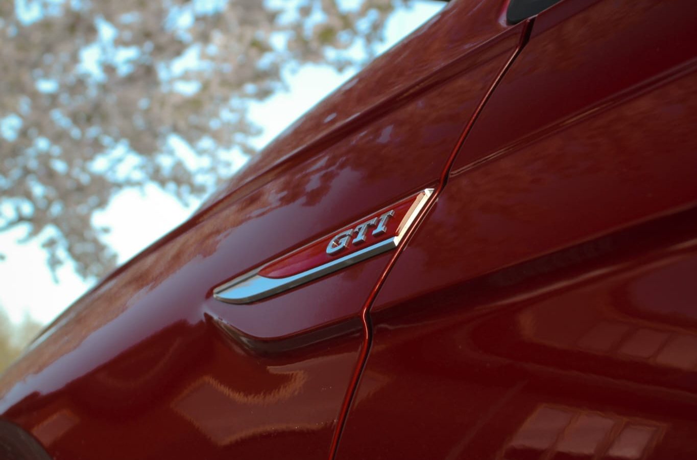 Close-up van een rode auto met GTI-badge